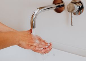 Person Cleaning Hands on Lavatory