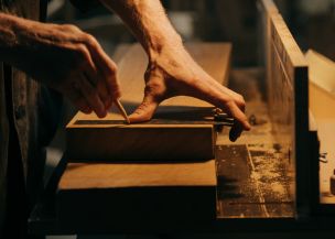 Person in Black T-shirt Holding Brown Wooden Table